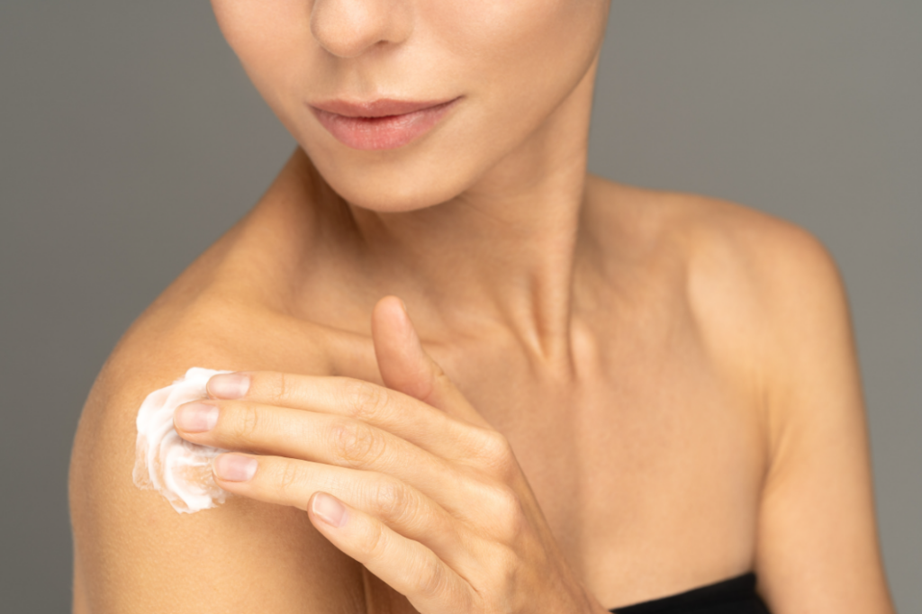 Photo of woman applying lotion on shoulder