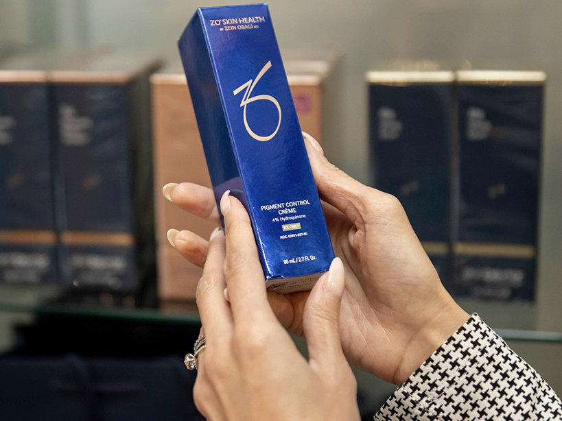 A woman is holding a box of a product in a Med Spa store in Chicago.