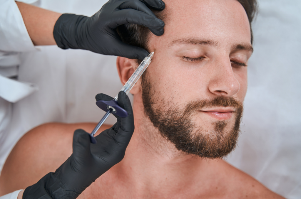 A beginner's guide to dermal fillers, showcasing a man receiving a syringe injection in his face.