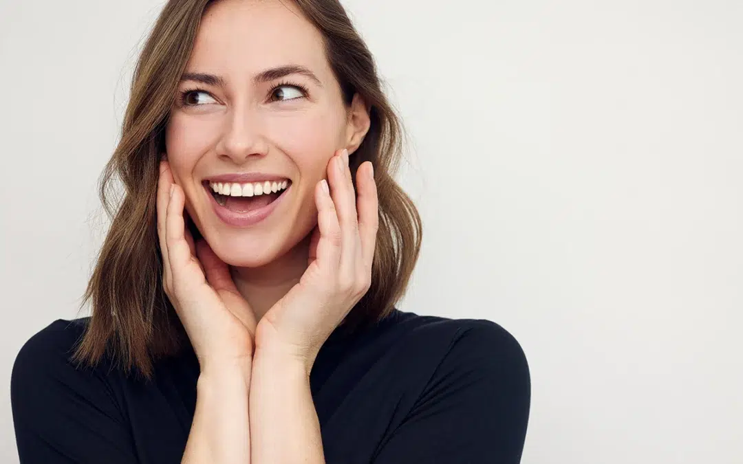 beautiful happy woman smiling and thinking with hands on her cheeks