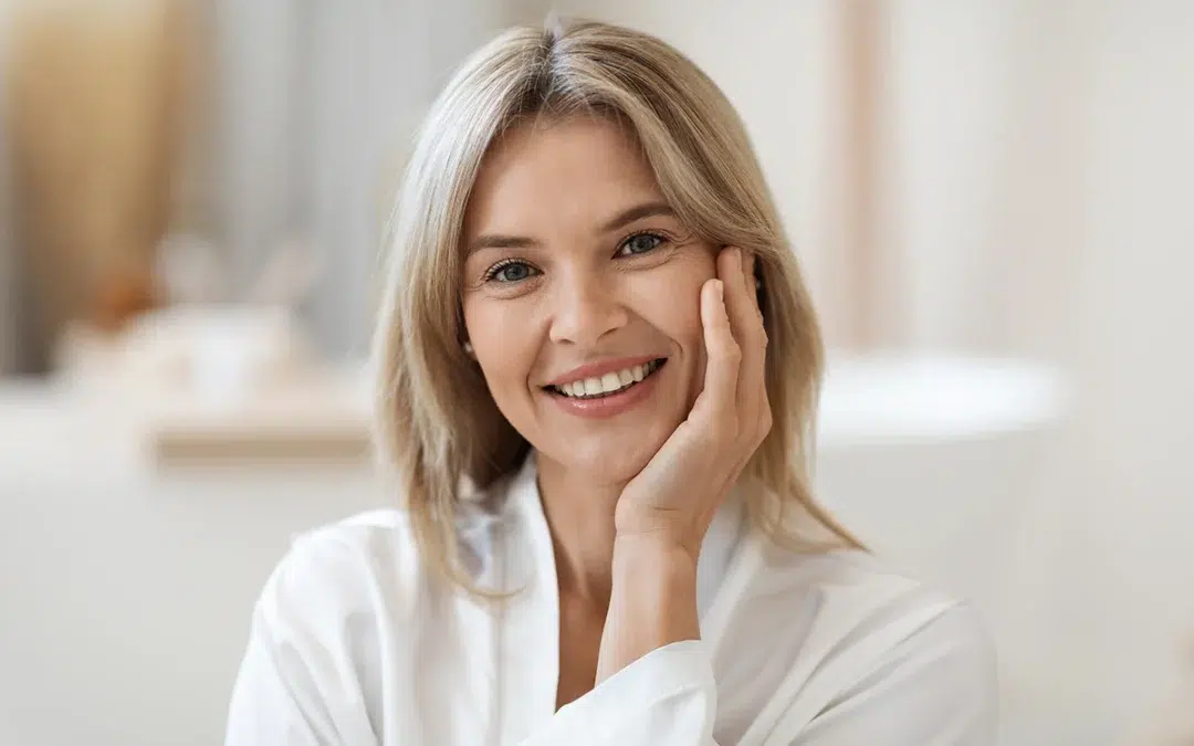portrait of smiling beautiful middle aged woman touching her cheek