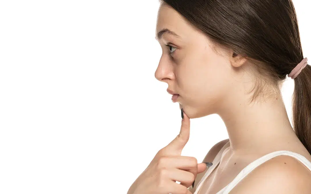 woman touches her chin with her fingers