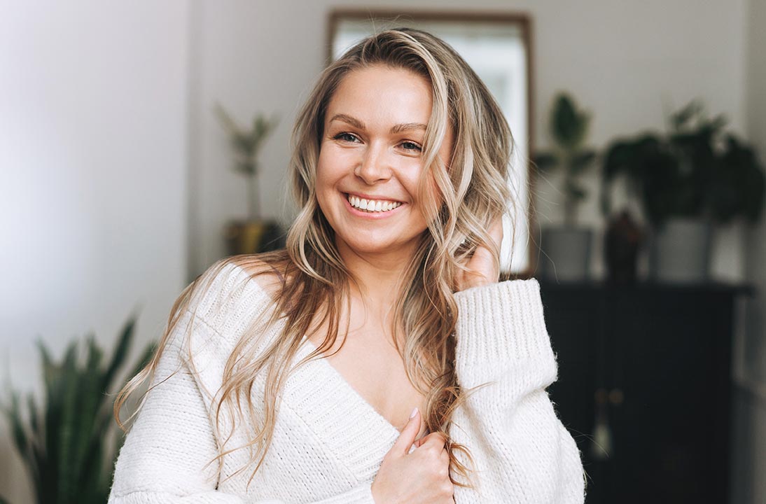 Blonde smiling woman year clean fresh face and hands with lon