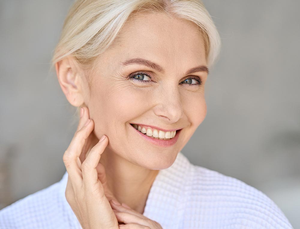 Portrait of smiling mid age woman looking at camera. Skin care concept.