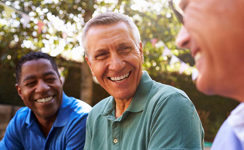 Mature Male Friends Socializing In Backyard Together