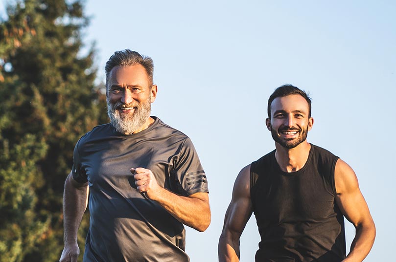 The happy father and a son running on a park road