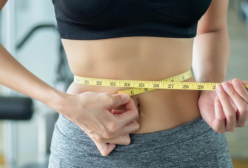 lim fitness woman working out in gym with waist measurement, portrait of fitness woman in gym
