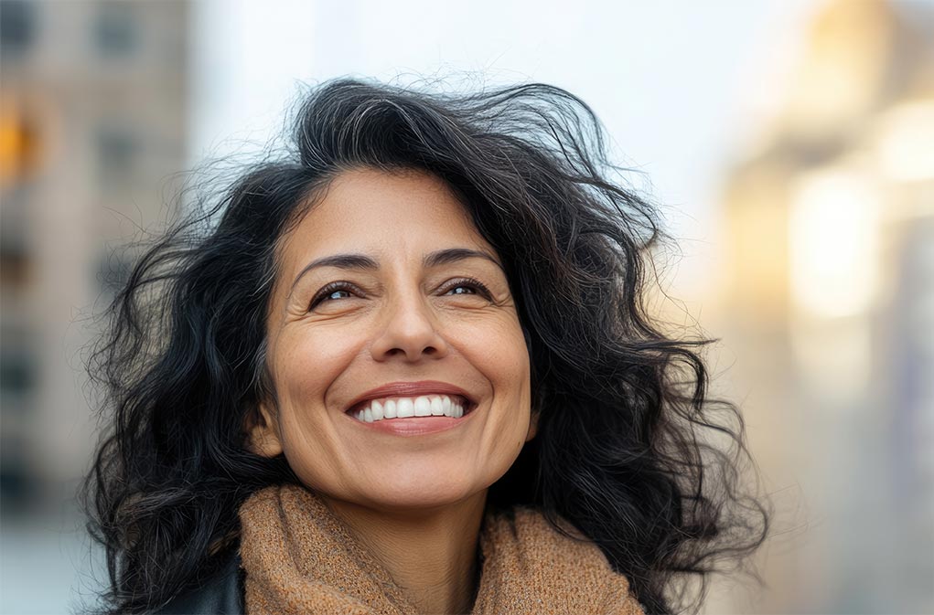 Happy Hispanic woman in city.<br />
