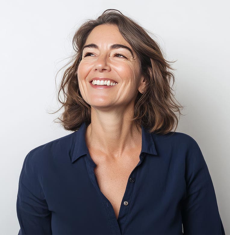 Beautiful senior woman in navy shirt smiles sideways.