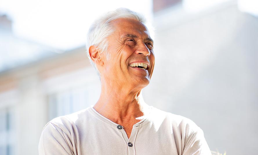handsome man smiling with arms crossed and looking away