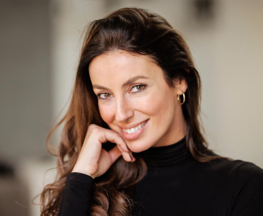 Portrait of an attractive woman wearing black turtleneck sweater and and cheerful smiling