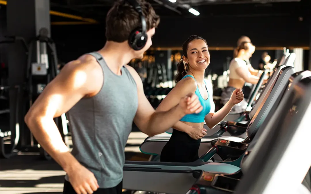 couple running on treadmills and talking with each other