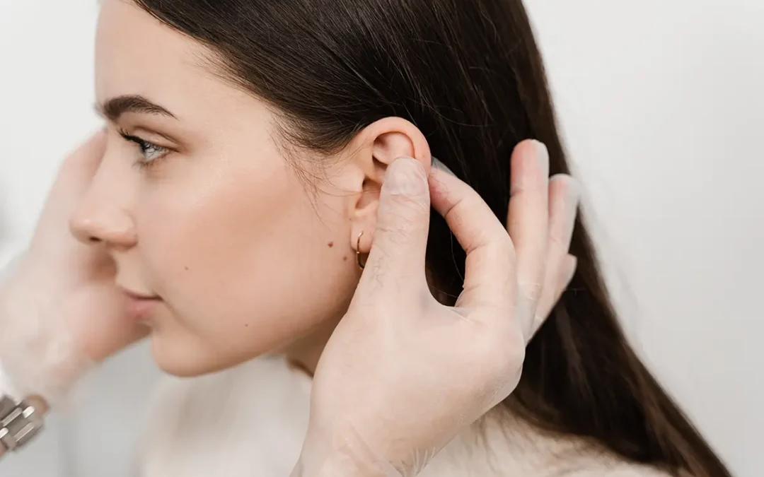 doctor examines girl ears before otoplasty